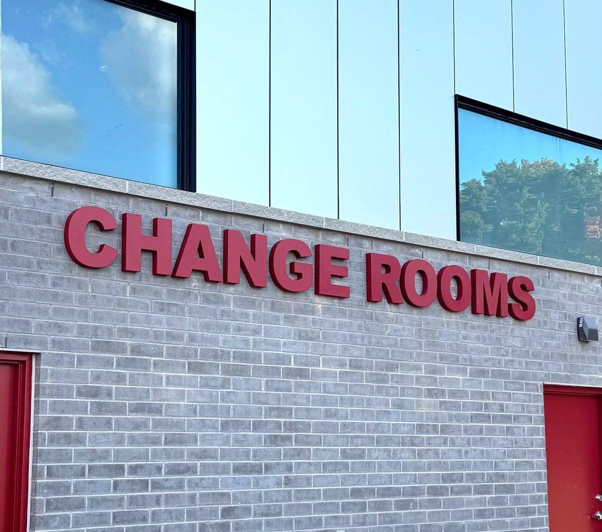 Red cut-out letters spelling Change Rooms mounted above facility doors