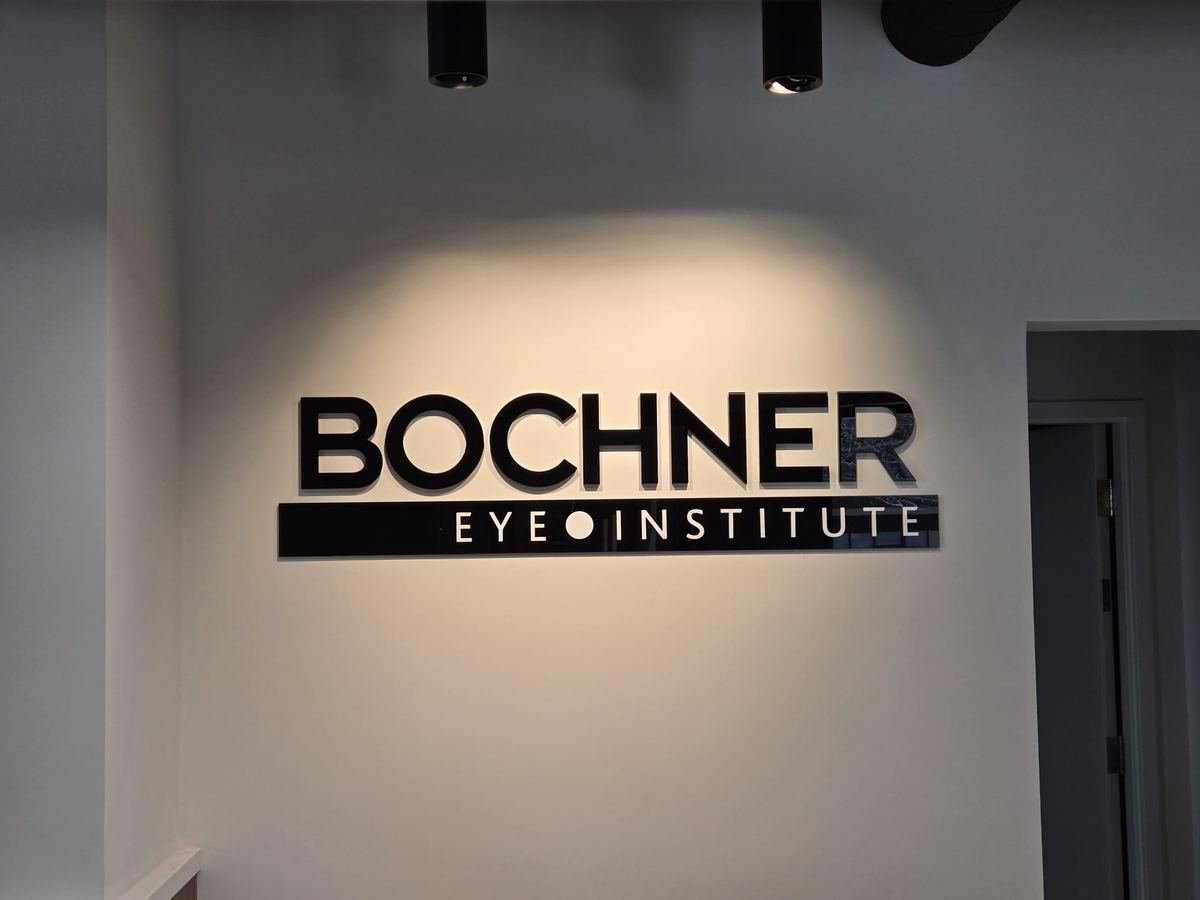 Black BOCHNER letters above a black EYE INSTITUTE band on a light grey lobby wall