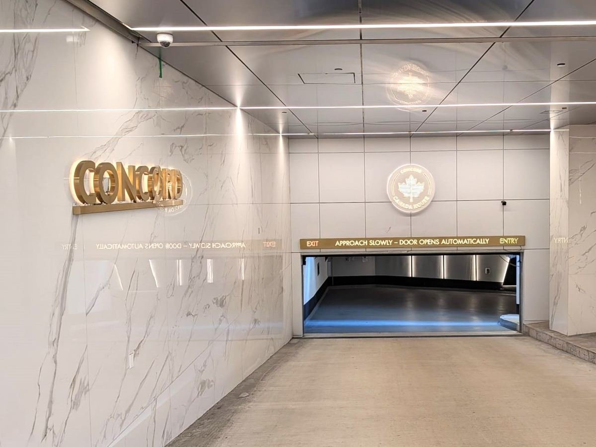 Gold CONCORD letters on the marble wall of a lobby beside a garage entrance